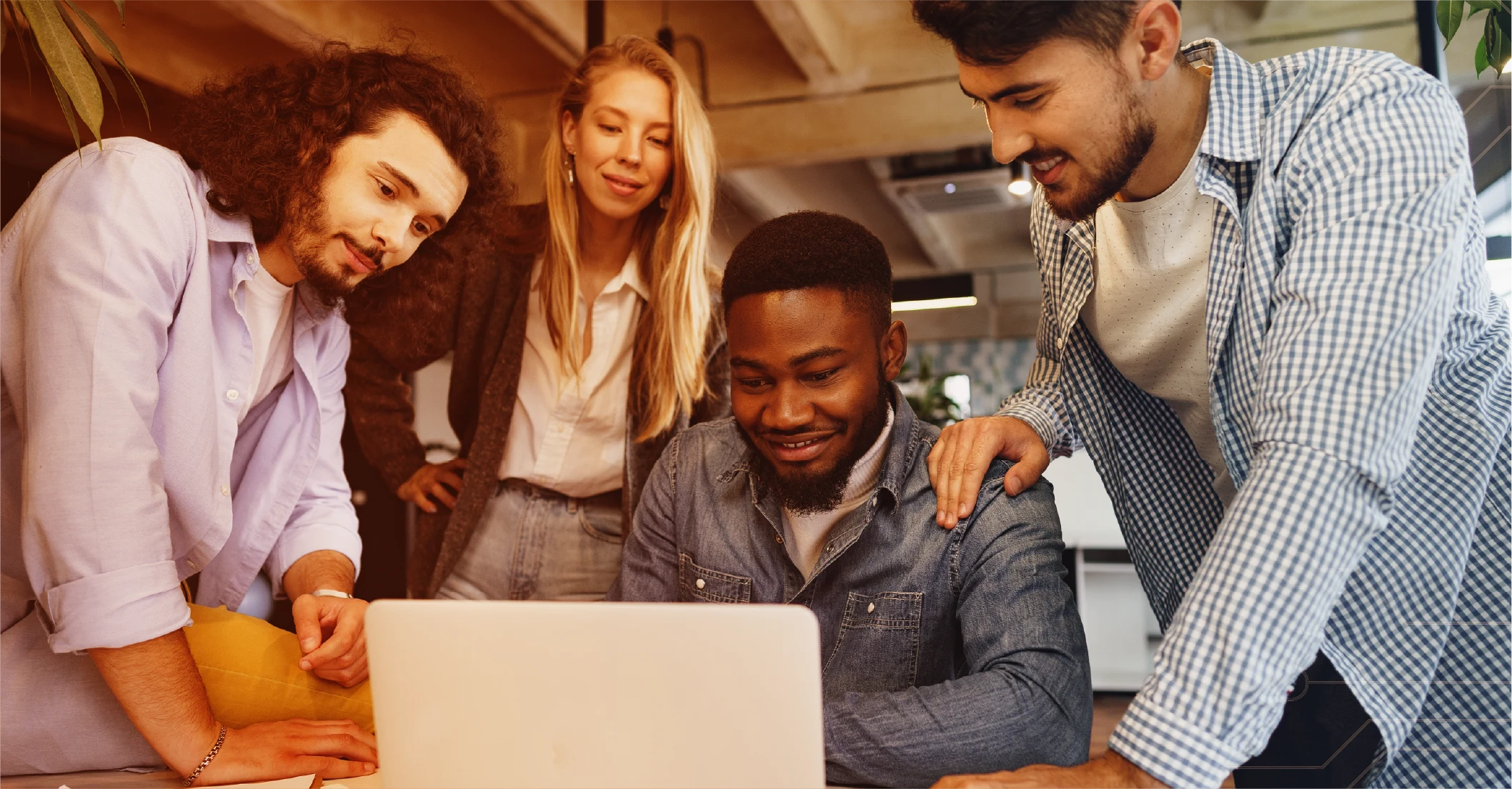 Equipo colaborando en un proyecto frente a un computador